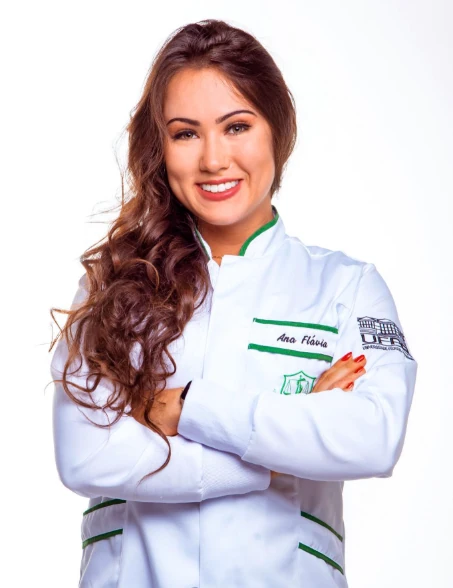 Ana Flávia, nutricionista, de braços cruzados e sorrindo